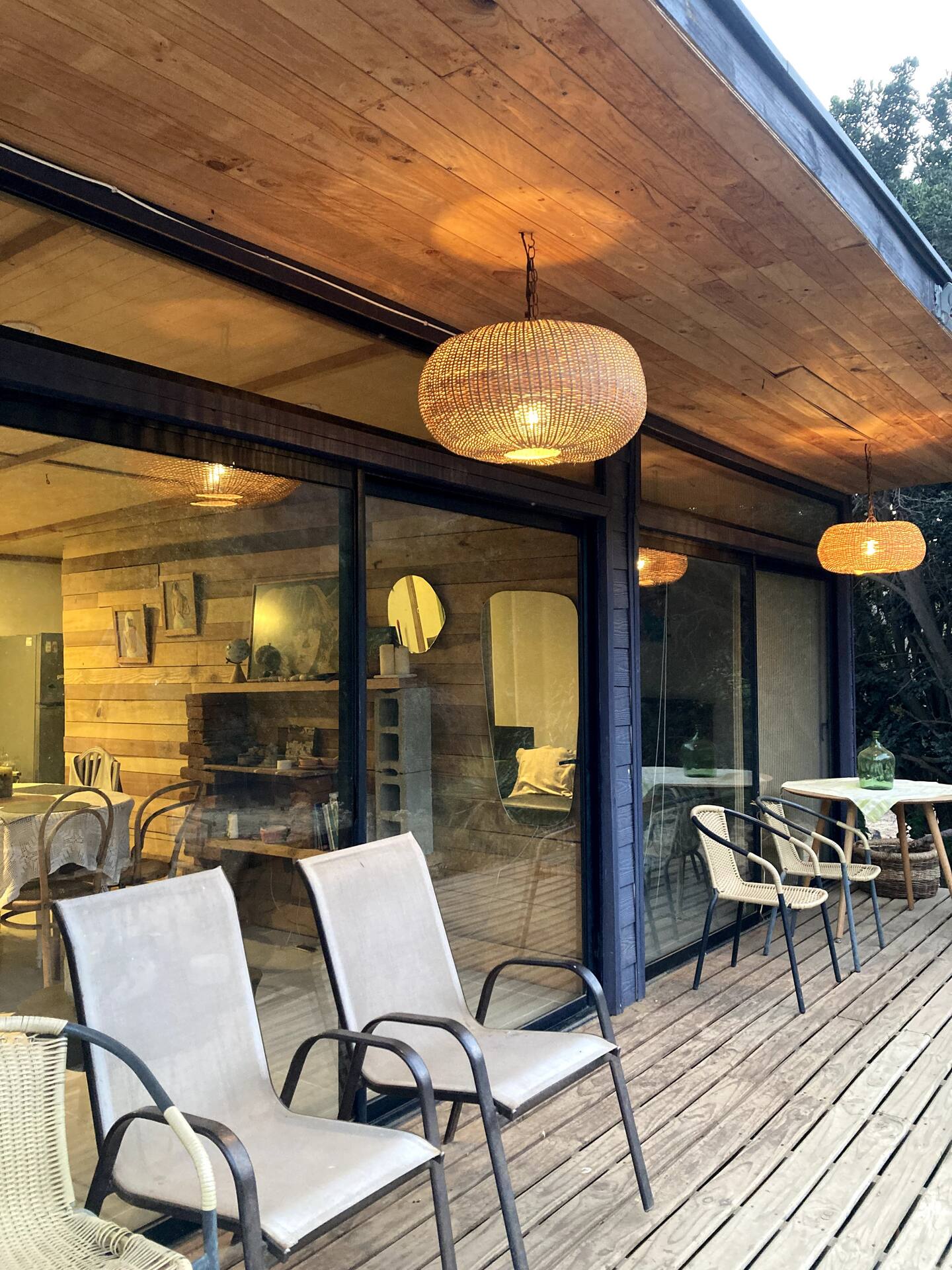 Terraza del refugio con lámparas colgantes y vidrio al interior