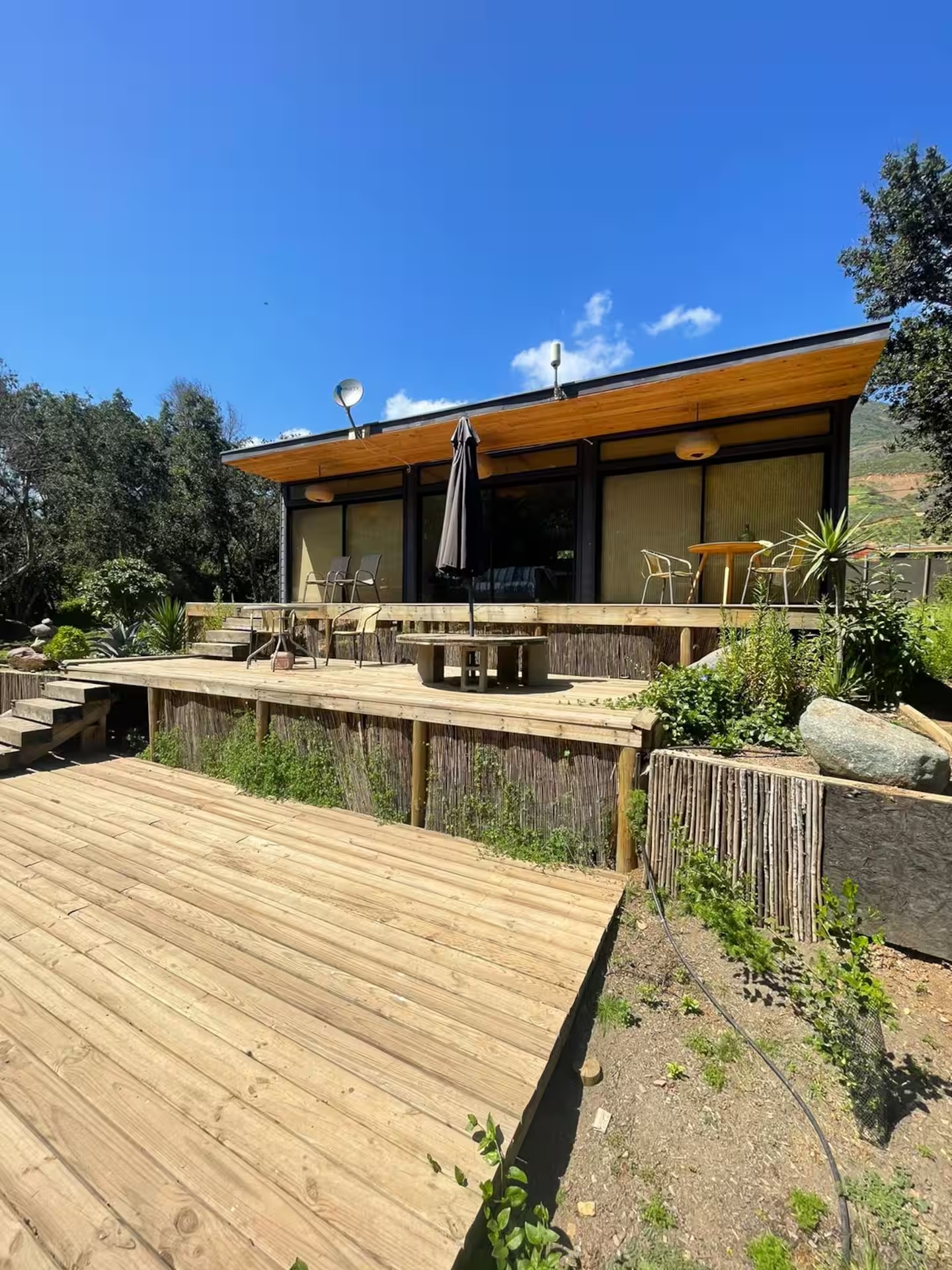 Fachada del refugio de madera con gran terraza elevada